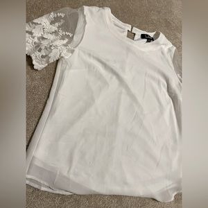 White dressy t-shirt with detailed sleeves.